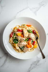 This image shows the Chicken Pot Pie Noodle Skillet being served on a plate, with tender noodles, colorful vegetables, and creamy sauce ready to enjoy.