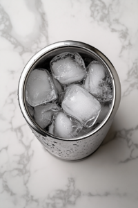 This image shows a bartender vigorously shaking a cocktail shaker filled with ice and margarita ingredients, ensuring a perfectly mixed and chilled drink.