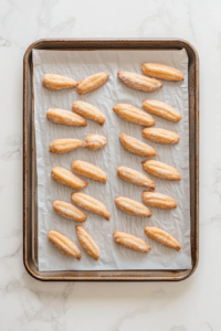 This image shows a knife being used to carve realistic knuckle lines into the dough, adding a creepy, lifelike detail to the witch finger cookies.