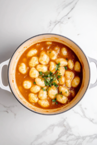 This image shows the sauce simmering in the pan, thickening into a flavorful, velvety consistency.