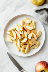 This image shows fresh apples being sliced, preparing them for the flavorful filling of the apple crumb pie.