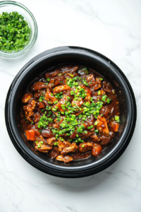 This image shows freshly chopped green onions being sprinkled over the Chicken and Vegetables Stir Fry, adding a pop of color and a mild onion flavor to the dish.