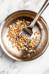 This step involves pouring chicken stock into the pan to deglaze, lifting all the flavorful bits stuck to the surface.