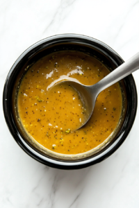 This image shows the finished broccoli cheese soup being stirred to ensure an even texture before being ladled into bowls, ready to be served and enjoyed.