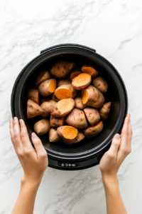 This image shows whole sweet potatoes inside a slow cooker, demonstrating that no poking or foil wrapping is needed for a soft and evenly cooked texture.