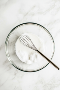 This image shows a mixing bowl filled with ice cream ingredients being whisked together to create a smooth and creamy base.