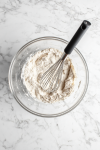 This image shows a smooth Yorkshire pudding batter being whisked in a mixing bowl, ensuring it is well combined and free of lumps for a perfect rise.