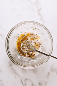 This image shows a bowl of eggs being whisked with seasoning to create a rich, flavorful mixture for the casserole.