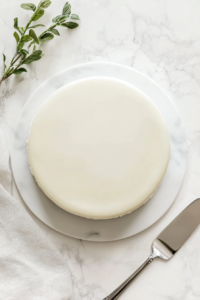 This image shows the finished White Mirror Glaze Cake, elegantly presented and ready to be enjoyed.