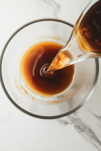 This image shows a mixing bowl filled with thick honey BBQ sauce being whisked together, blending the sweet, smoky, and tangy flavors perfectly.