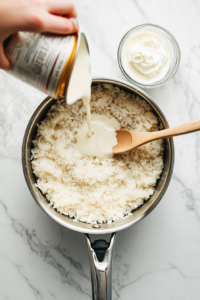 adding-condensed-milk-cream-and-vanilla-to-rice-for-rich-and-creamy-rice-pudding