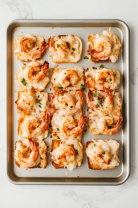 This image shows the Cheesy Shrimp Tea Sandwiches being baked in the oven, golden and crispy on top.