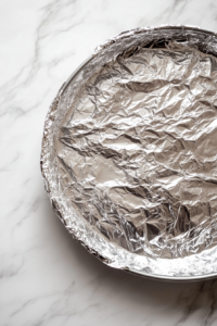 flan-mold-securely-covered-with-aluminum-foil-before-baking-in-a-water-bath