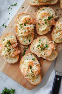 This image shows the shrimp mixture being spread evenly on slices of bread to prepare the Cheesy Shrimp Tea Sandwich.