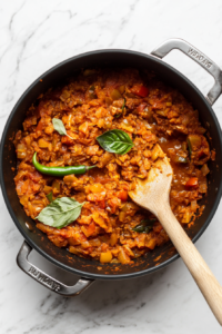 cooking-tomatoes-spices-heavy-bottomed-pot-white-marble-background